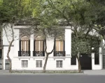 Facade of a 19th-century Haussman-style building, with cast-iron balconies. Three trees are in front of the gallery.