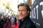 Smiling man on a red carpet.