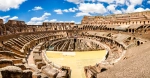The Coliseum, also known as the Flavian Amphitheater in Rome, Italy. A wide-angle shot of a sunny day inside the coliseum.
