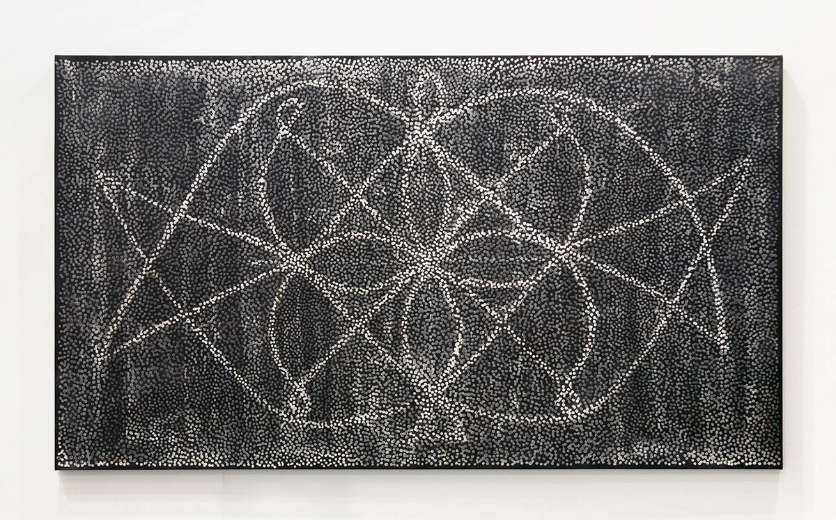 An abstract dot painting that is mostly black and gray with a patter of white that resembles flora.