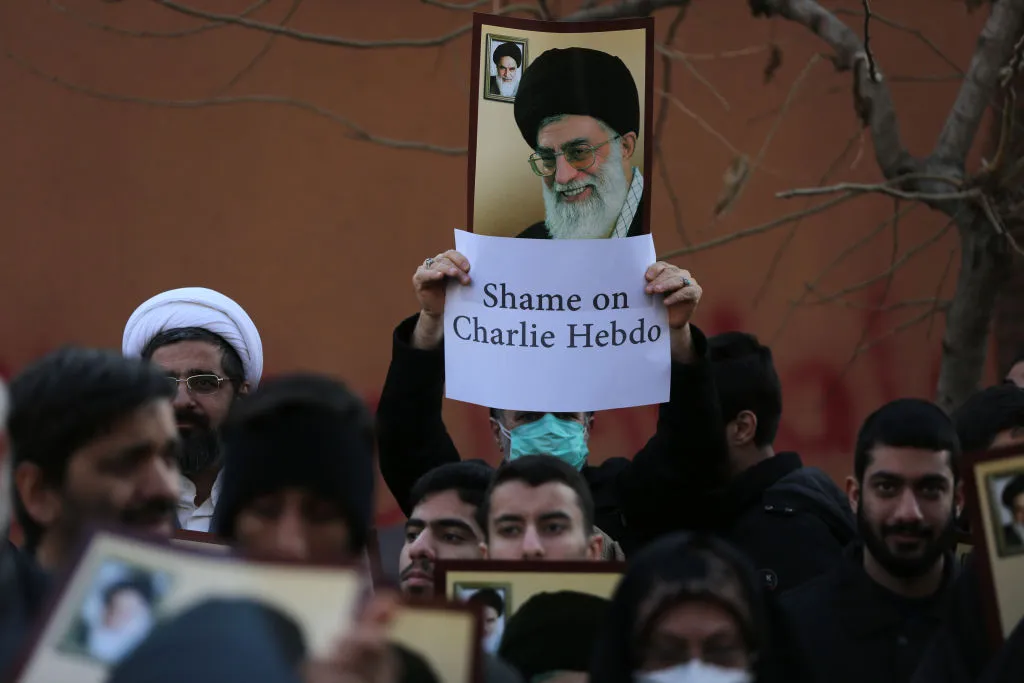 Protestors holding signs and images of religious leader.
