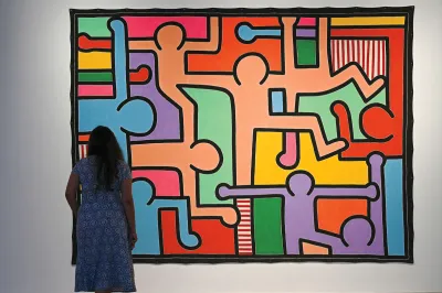 A visitor looks at the untitled work by American artist Keith Haring during the