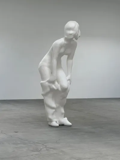 A paper sculpture that looks like marble of a woman who is in a state of undress.