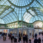 A crowd of people beneath a glass dome.