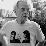 A white man in a T-shirt showing a woman