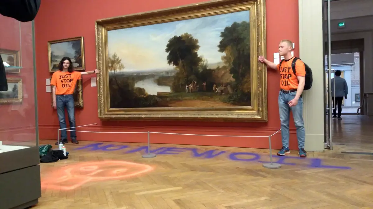 two men with their hands glued to the gilt frame of a painting.