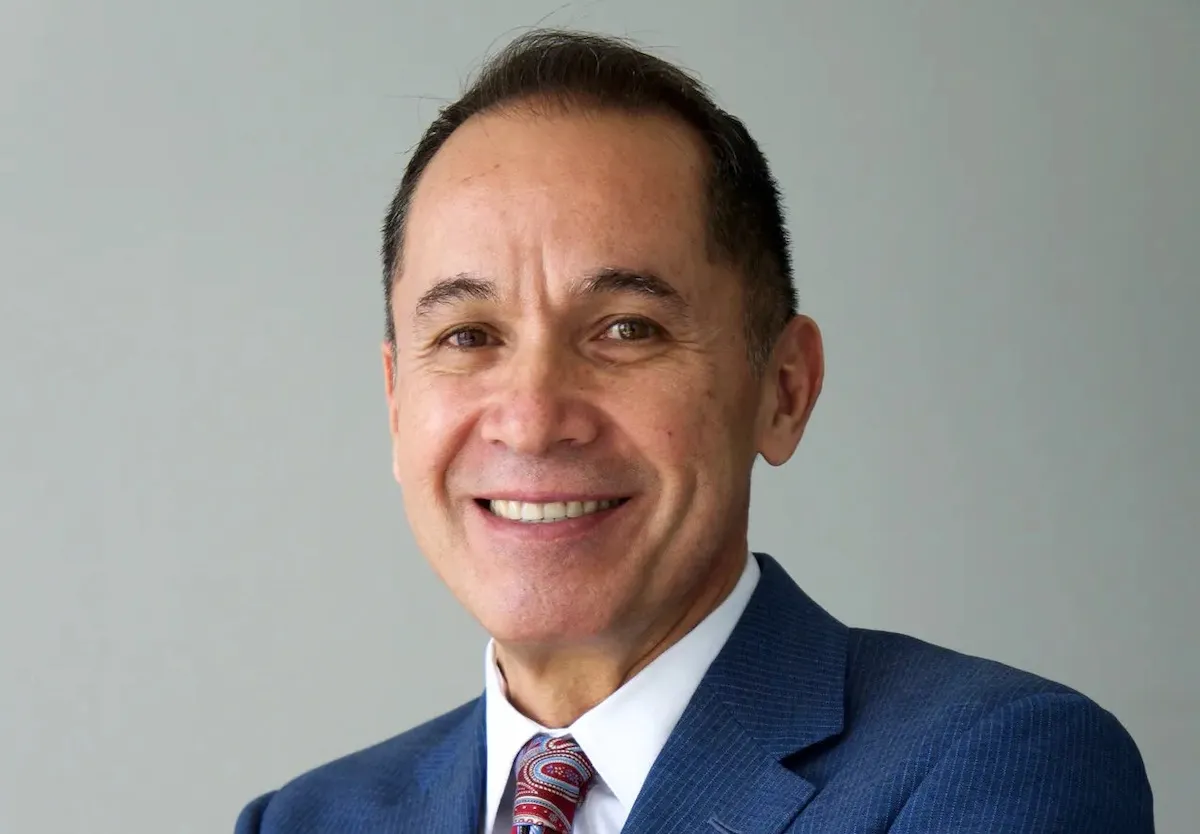 A man in a suit smiling.