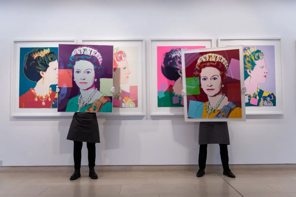 LONDON, ENGLAND - MARCH 26: Queen Elizabeth II, from: Reigning Queens is displayed alongside Queen Margarethe II of Denmark, both by Andy Warhol during preparations ahead of online sales at Christies Auction House on March 26, 2021 in London, England. The sale includes "The Prints & Multiples" and "Banksy: I Can