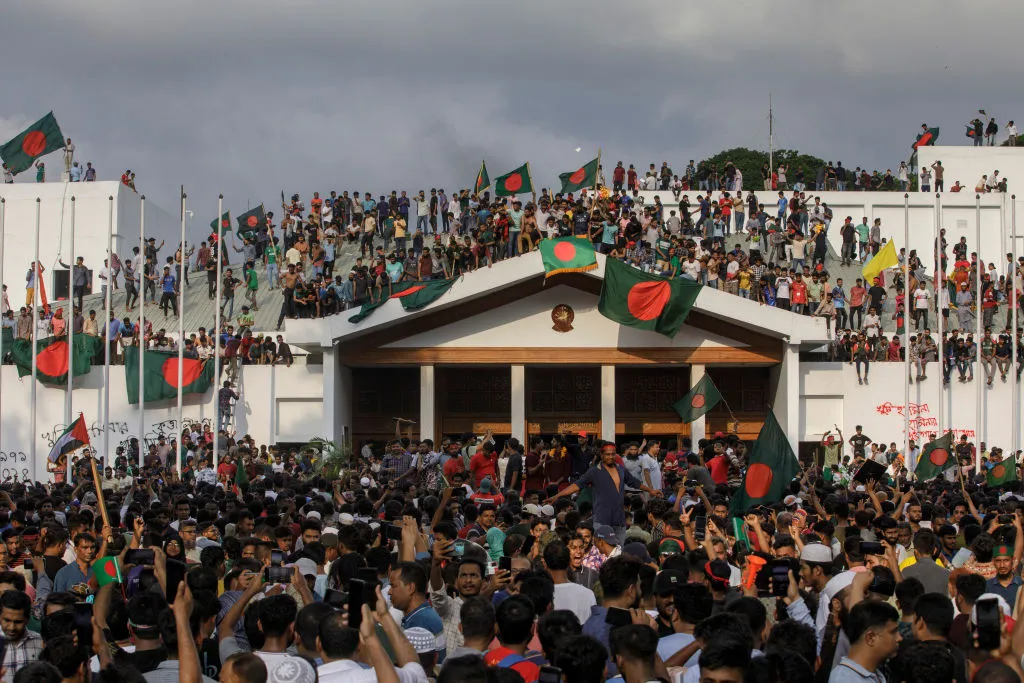 A group of people swarming a house.