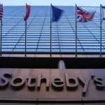 A skyscraper with flags and a sign reading Sotheby