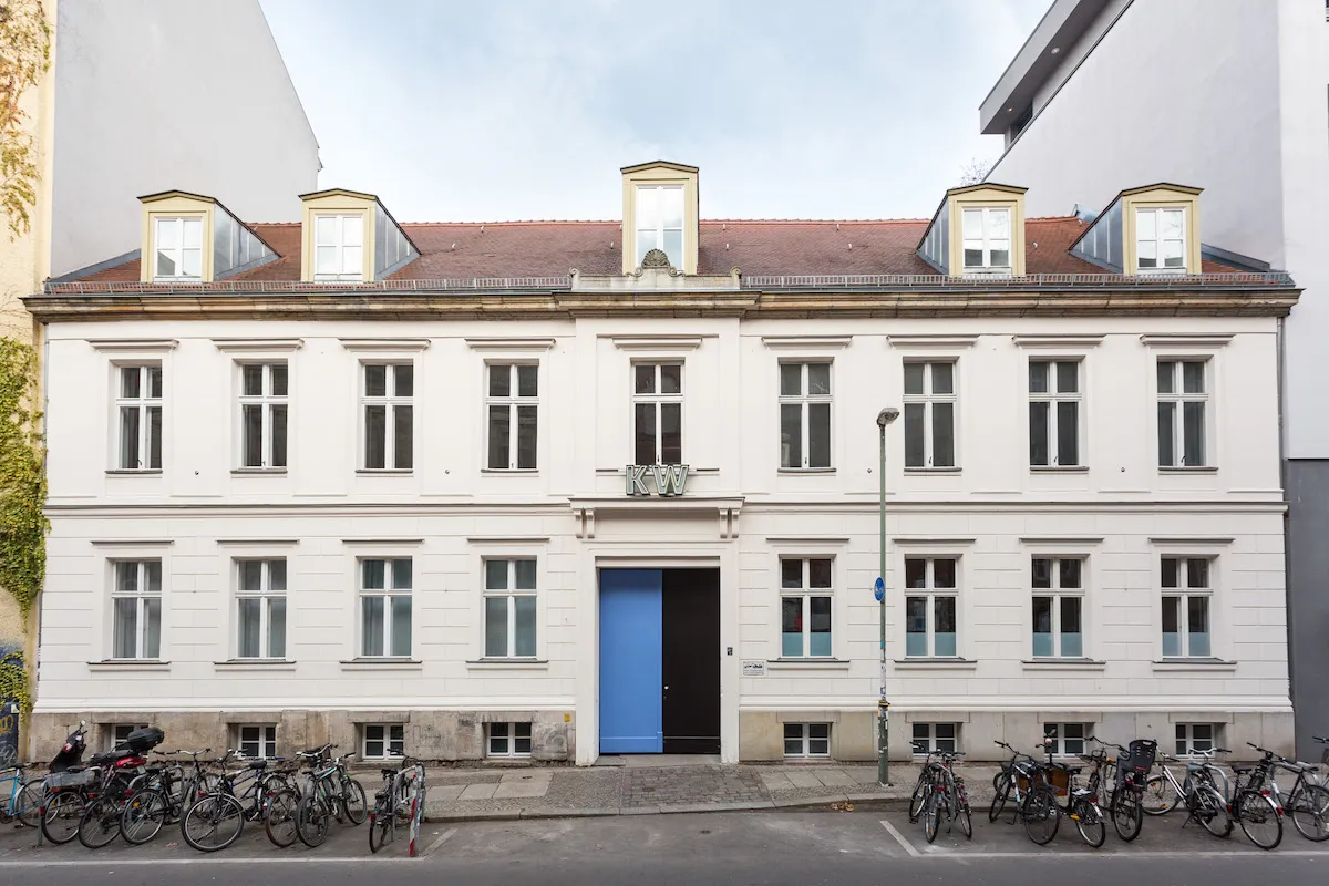 A museum facade with bicycles parked in racks before it.