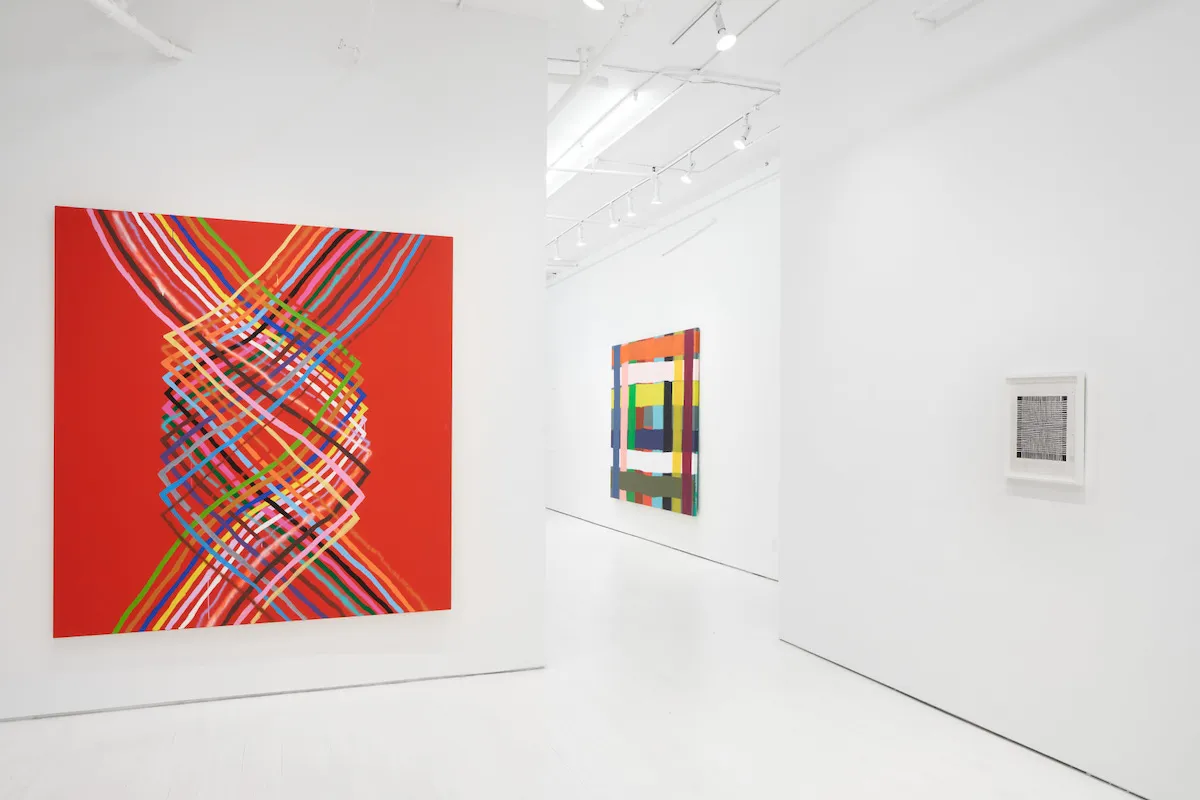 A gallery hung with abstract paintings.