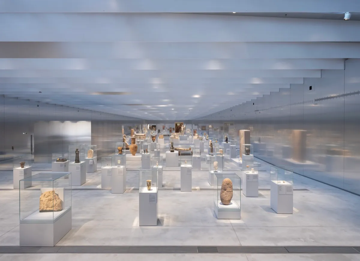 Many vitrines with ancient objects in a grey and silver room.