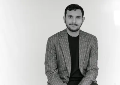 A man in a striped suit jacket and black T-shirt.