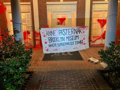A house with a banner tied to its two columns that reads 