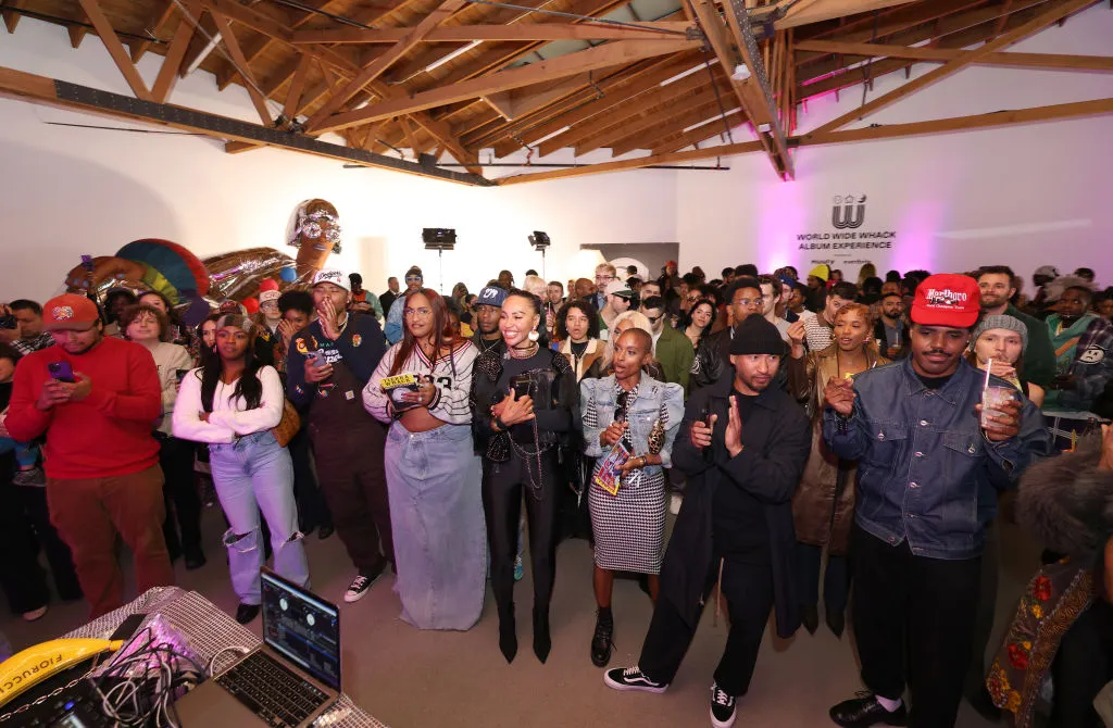People gather under an exposed wooden roof.
