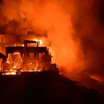 A beach house is engulfed in flames as the Palisades Fire burns along Pacific Coast Highway in Malibu, California, on January 8, 2025. At least five people have been killed in wildfires rampaging around Los Angeles, officials said on January 8, with firefighters overwhelmed by the speed and ferocity of multiple blazes -- including in Hollywood. (Photo by AGUSTIN PAULLIER / AFP) (Photo by AGUSTIN PAULLIER/AFP via Getty Images)