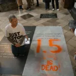 Two people next to a grave inside a church.