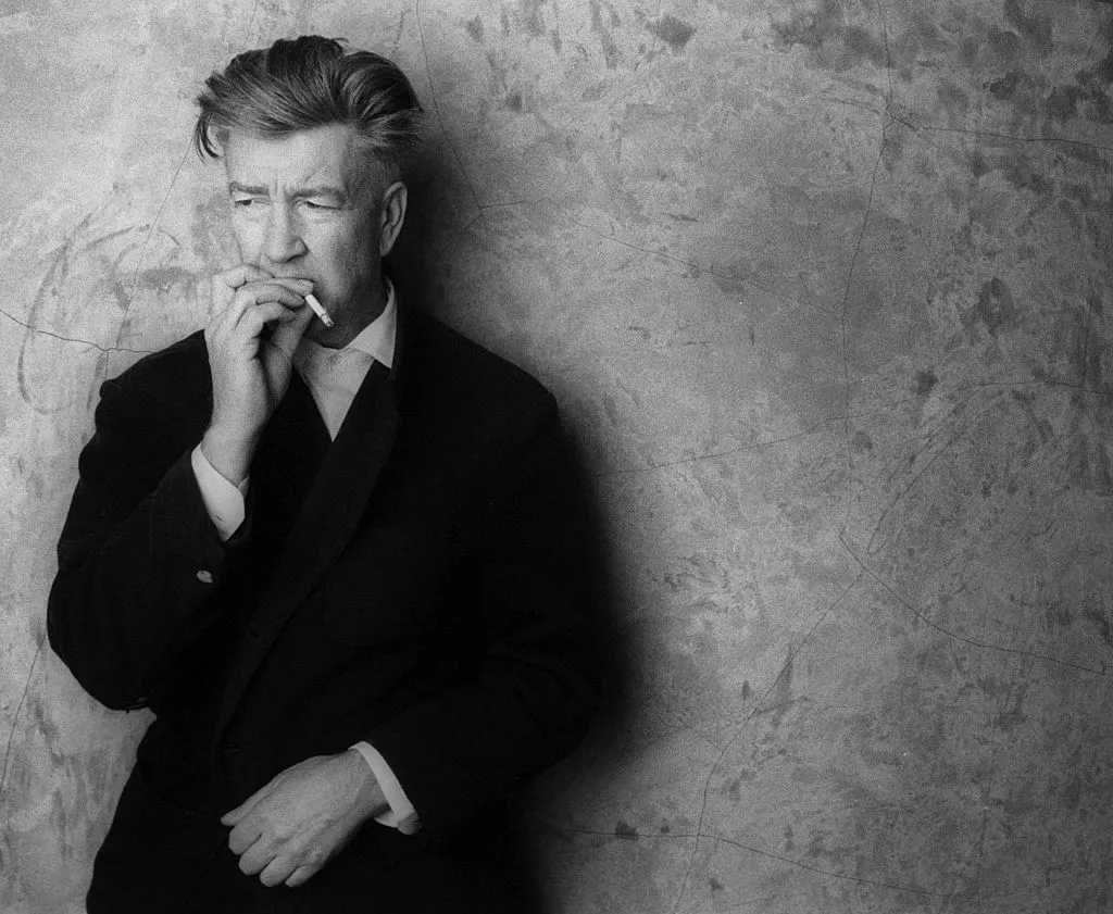 A man in a suit smoking a cigarette.