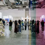 A performance artist (left) walks through the aisles of ART SG