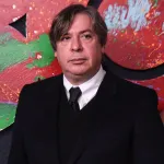 A man in a black suit and white shirt.