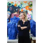 Justine Wheeler Koons, the wife of contemporary artist Jeff Koons, stands in front of bright blue several glazed stoneware sculptures that will be included in a solo exhibition 
