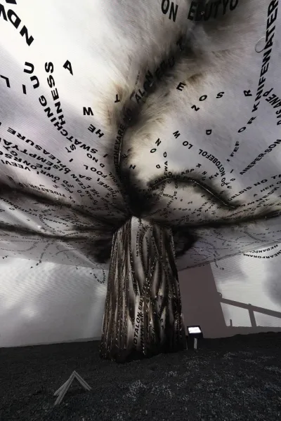 An installation that appears to be a tornado of words is on view in a gallery.