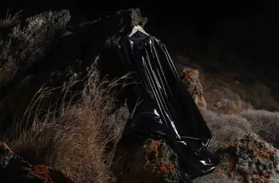 A hanger holding a black, rubbery garment. The hanger is hung from a rock.
