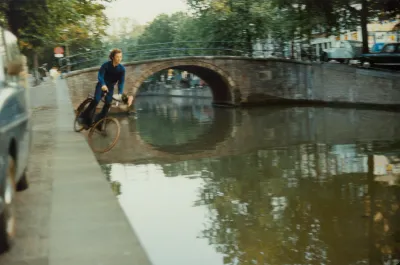 A man riding a bicycle into a canal.