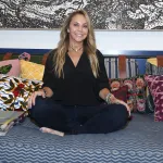 A woman sitting cross-legged on a couch.