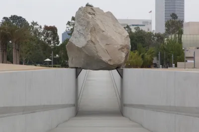A giant boulder situated above a ramp so that it appears to float.
