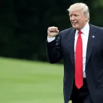 A man in a suit pumping his fist.