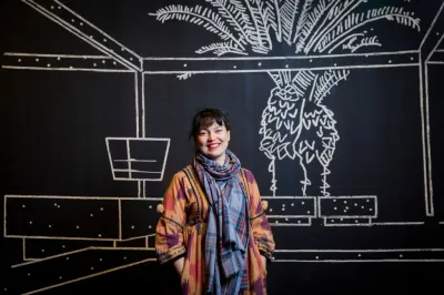 Yto Barrada standing in her exhibition 