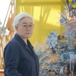 Portrait of artist Lee Bul in her studio in front of a sculpture.