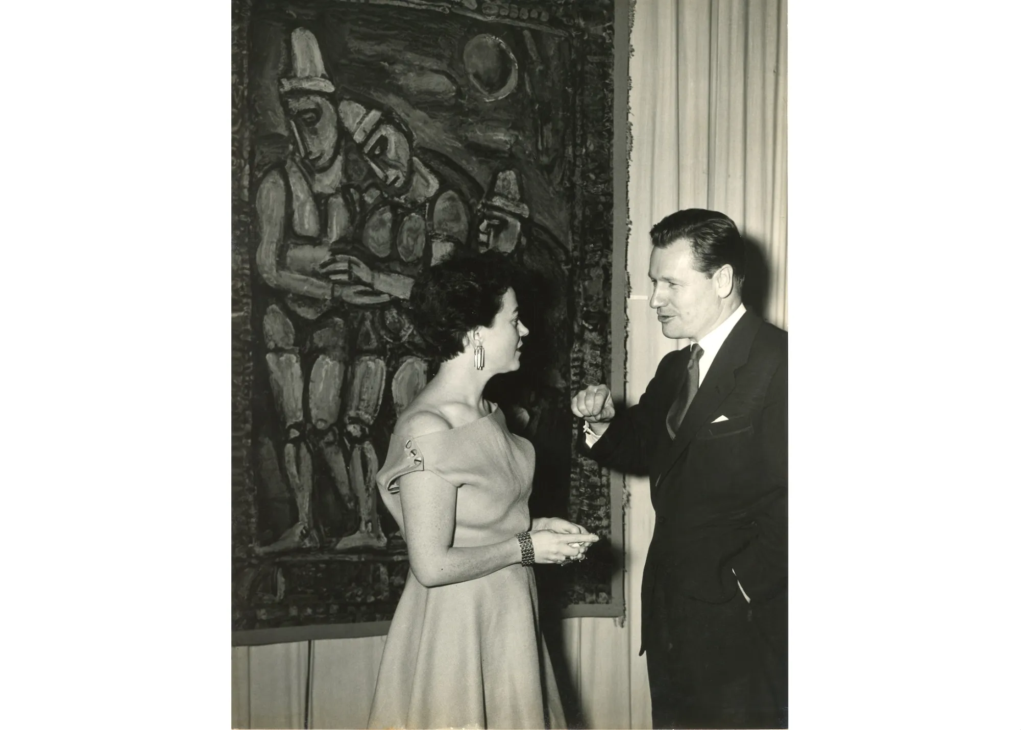 A man and woman in front of a painting.