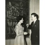 A man and woman in front of a painting.