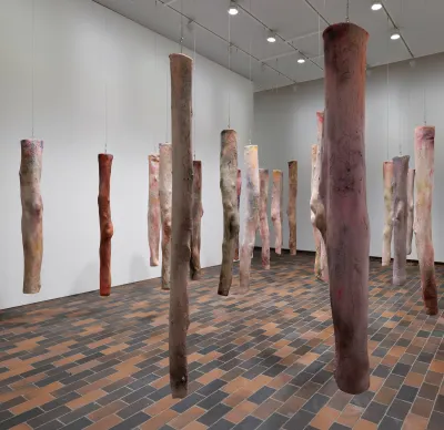 A group of hanging sculptures resembling legs.