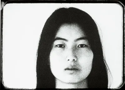 Film still of an Asian woman staring at the camera.