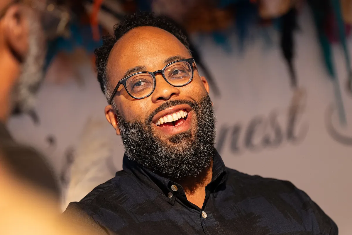 A smiling man in a black shirt.