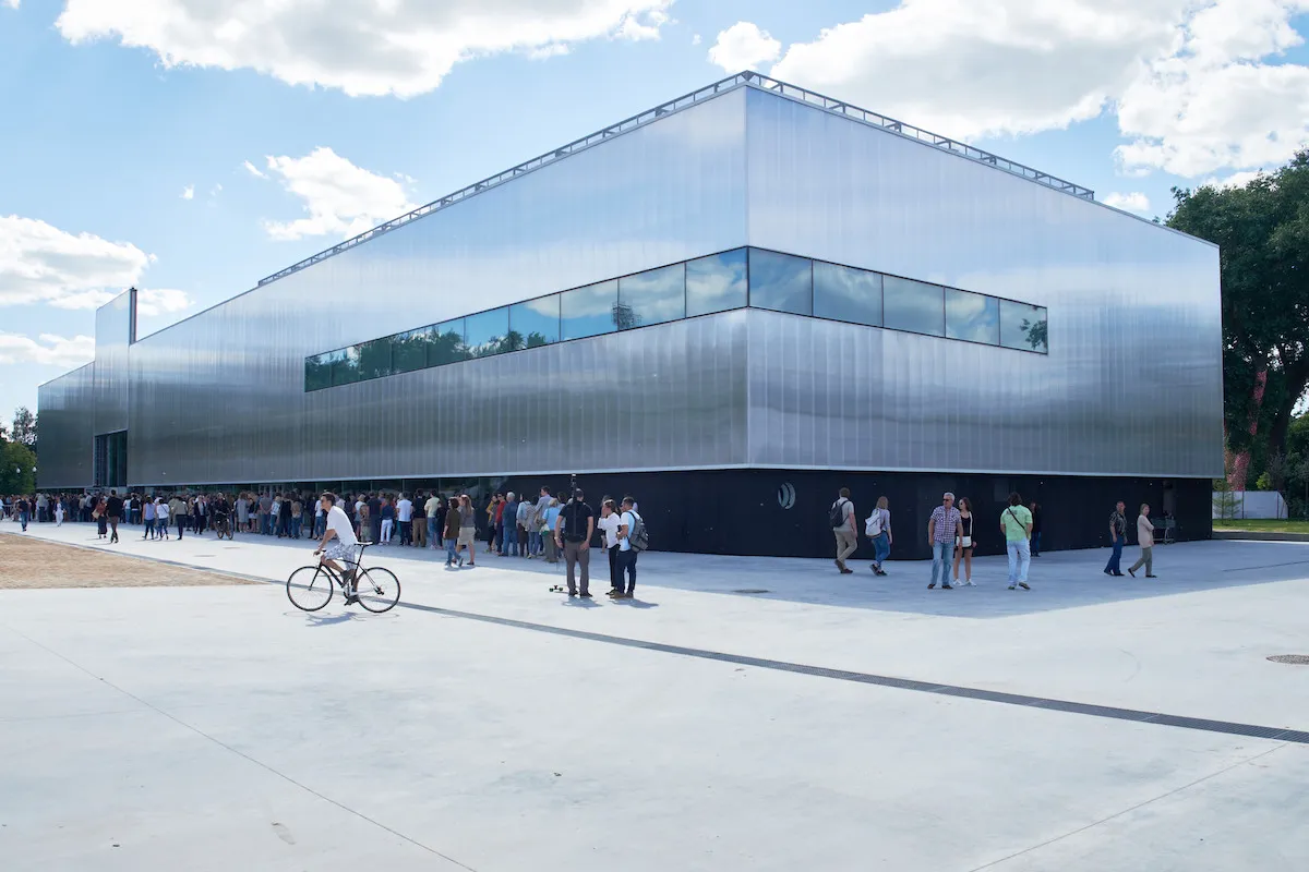 A blocky museum building with people standing in front of it.