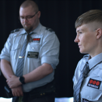 Three actors dressed in blue uniforms.