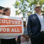 A person holding a sign that reads 