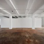 View of an empty gallery with hardwood floors.