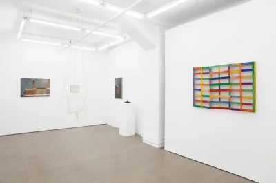 View of a gallery exhibition showing artworks of different mediums.