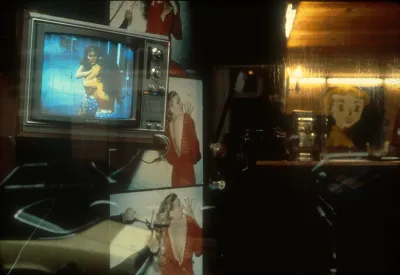 A monitor showing Wonder Woman in a hair salon storefront.