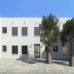 View of a courtyard of a two-story building with two trees on the right.
