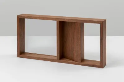 A sculpture of wood that is bisected. One half is fully inset with glass. The other half is half wood and half glass.