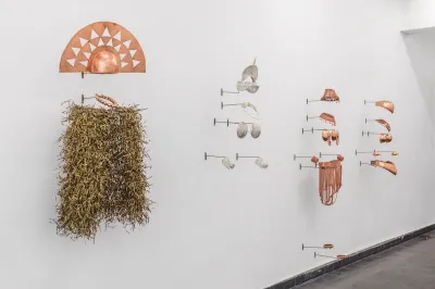 Several artworks resembling costumes whose armor-like parts are made of copper.