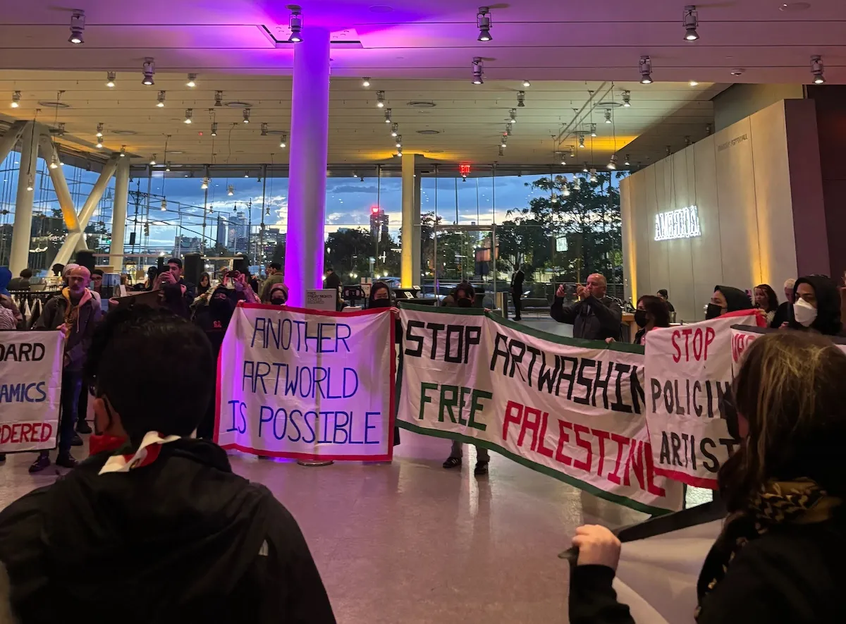 A group of protestors in a museum lobby.