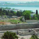 An archaeological ruin with a body of water in the background.